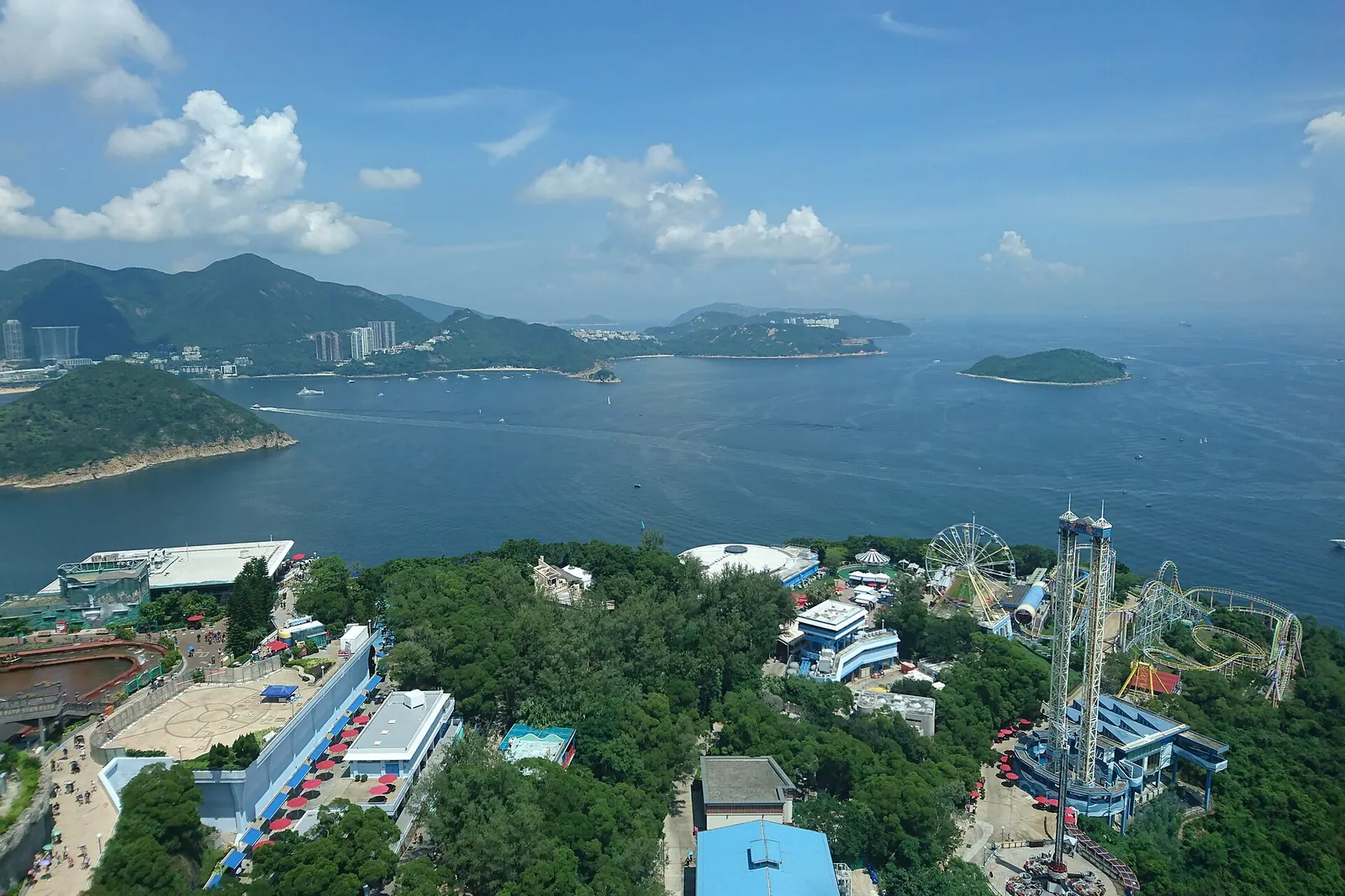 An aerial view of the Summit with a drop tower, a Ferris wheel and a wide bay